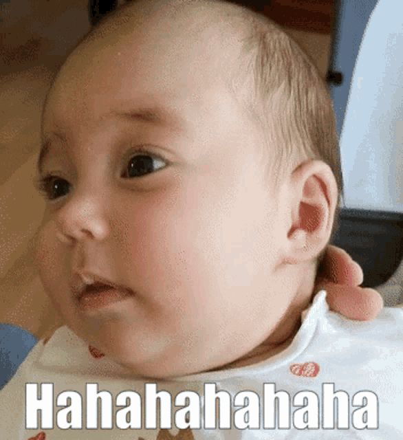a baby is being held by a person and the baby is laughing with the words hahahaha on the bottom right