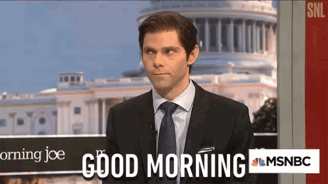 a man in a suit and tie is standing in front of a sign that says " good morning "