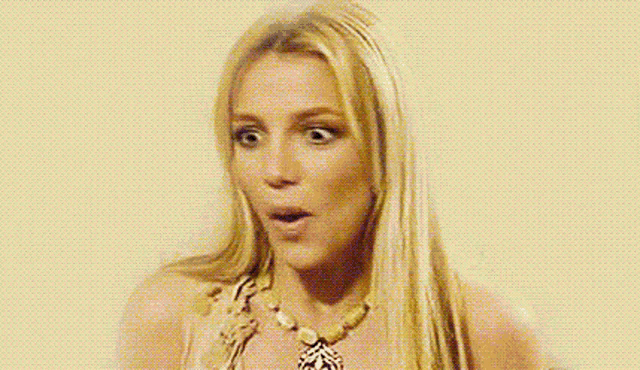 a woman with long blonde hair is wearing a necklace and looking surprised .