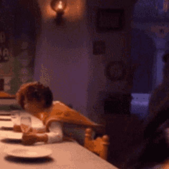 a blurry picture of a person sitting at a table with plates on it