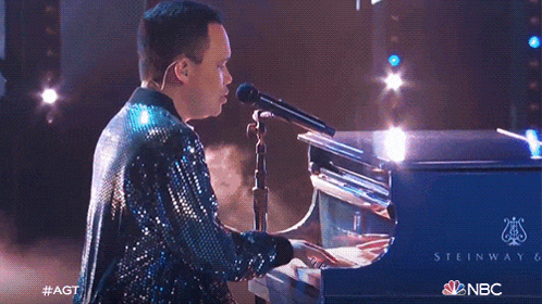 a woman in a sequined dress is playing a piano with the letters nbc on the bottom