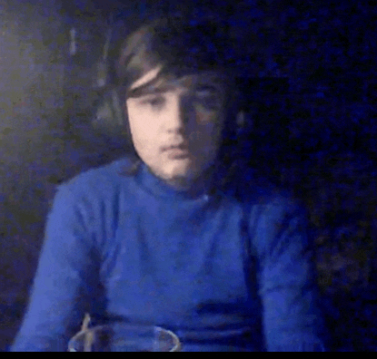 a young man wearing headphones and a blue sweater