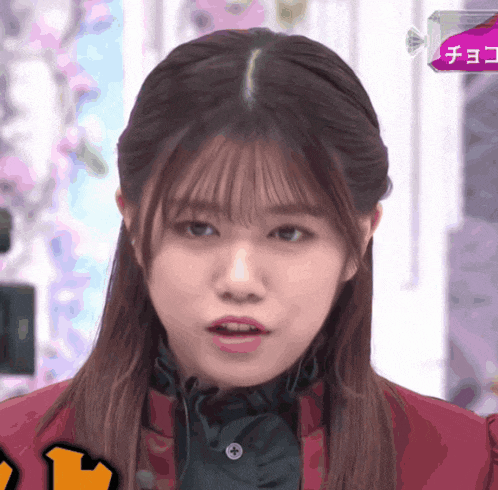 a close up of a girl 's face with a box of chocolate behind her