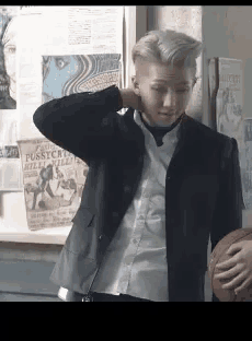 a man in a suit and tie is holding a basketball in his hand .