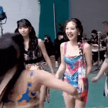a group of young women are standing next to each other in a room and smiling .