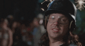 a man with long hair wearing a helmet and gloves is making a funny face .