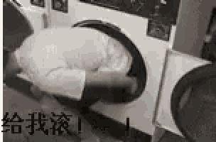a man is kneeling down in a washing machine with his head in it .