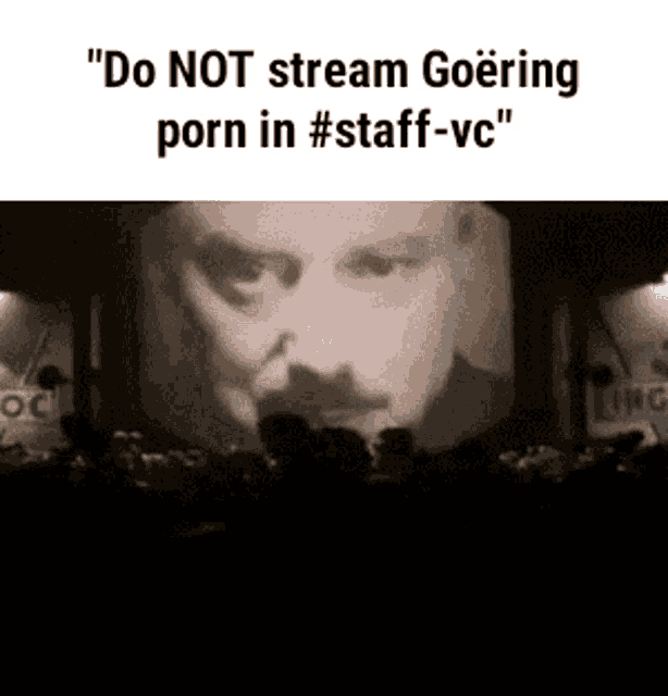 a man 's face is projected on a large screen with the words " do not stream goering porn in #staff-vc "