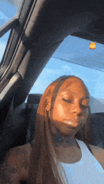 a woman is sitting in the back seat of a car with her eyes closed .