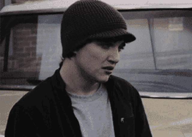 a man wearing a beanie and a jacket with the letter f on the front