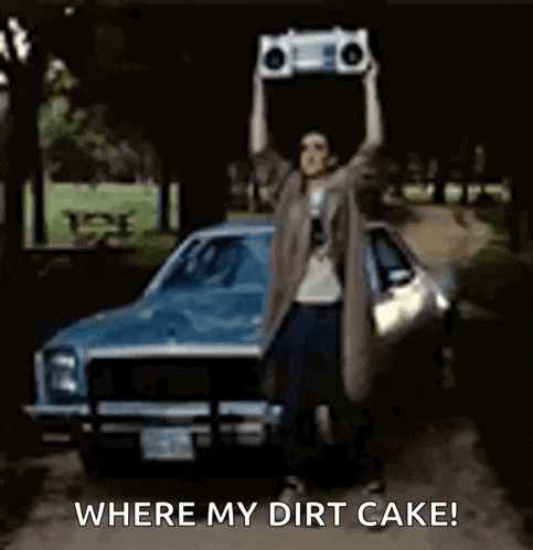 a person is holding a boombox over their head in front of a car and says where my dirt cake .