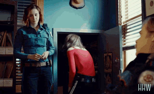 a woman in a red shirt is standing next to a woman in a blue shirt with the word hw on the bottom right
