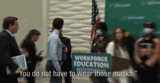 a group of people are standing around a sign that says workforce education
