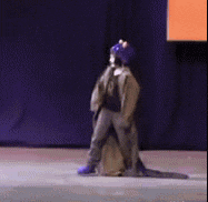 a person in a purple hat is standing on a stage
