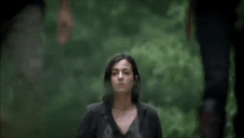 a woman with a backpack is standing in the woods