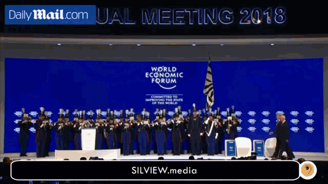 a group of people are standing in front of a stage that says world economic forum