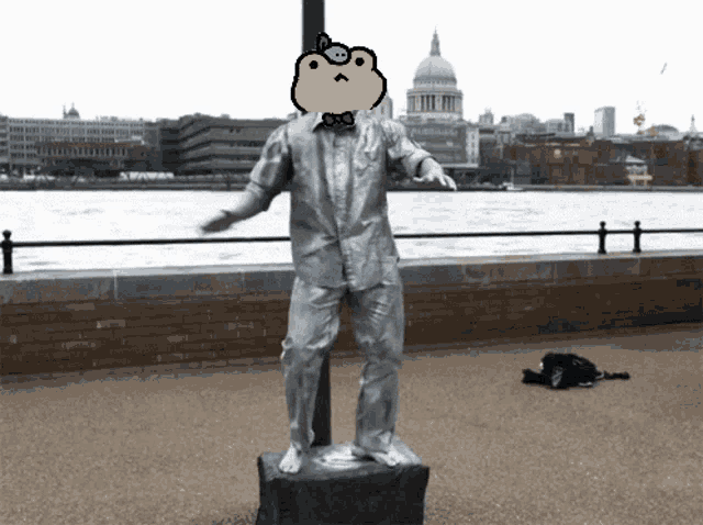 a statue of a man in a suit with a frog on his head