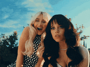 two women one blonde and one black are posing for a photo