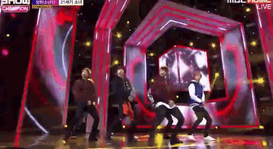 a group of people are dancing on a stage in front of a sign that says show