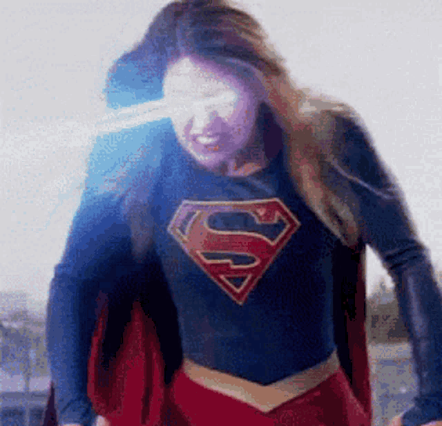 a woman in a superman costume is standing in front of a white background .