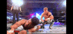 two men are fighting in a boxing ring while a referee looks on .