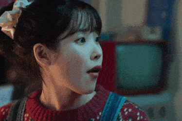 a close up of a woman wearing a red sweater