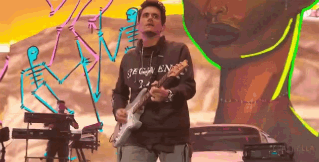 a man is playing a guitar and wearing a shirt that says " begin en "