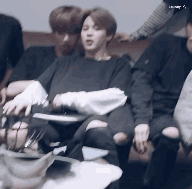 a group of people are sitting on a couch and the word laundry is on the bottom right
