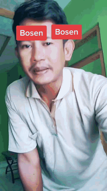 a man wearing a white shirt has a red sticker on his forehead that says bosen