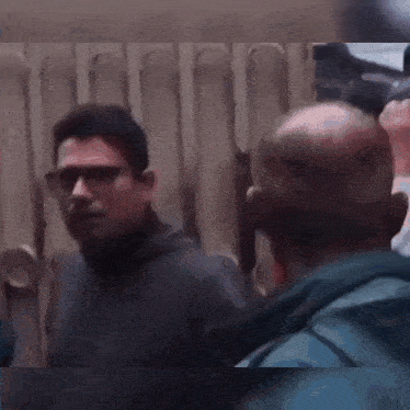 a blurry picture of two men standing next to each other