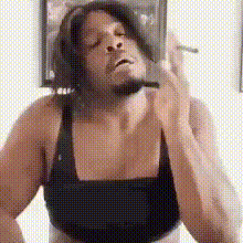 a man wearing headphones and a black bra is smoking a cigarette