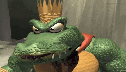 a cartoon crocodile wearing a gold crown and a red sash