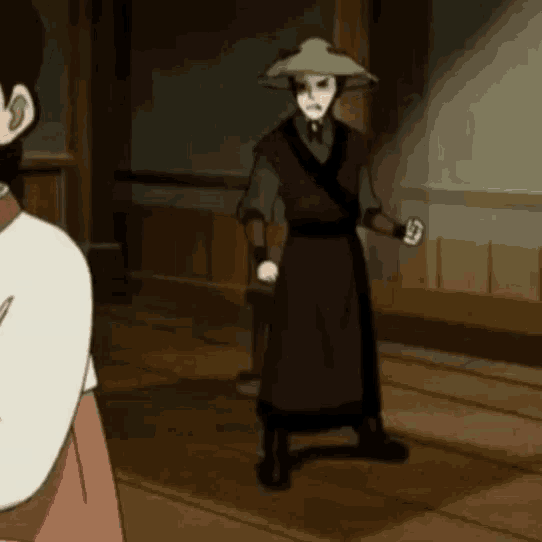 a man in a hat is standing in a room next to a woman in a white dress .
