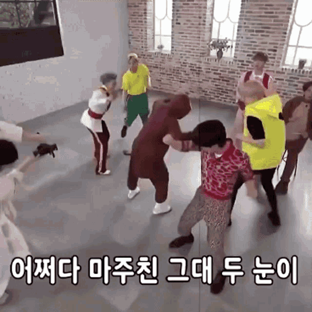 a group of people are dancing in a room with korean writing on the bottom