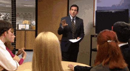 a man in a suit and tie giving a presentation to a group of people