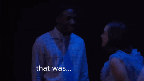 a man and a woman are standing next to each other in a dark room and the man is saying `` that was ... '' .