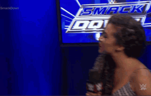 a woman stands in front of a smackdown sign