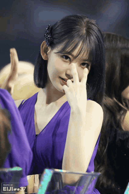 a woman in a purple dress has a photo by eiji 37