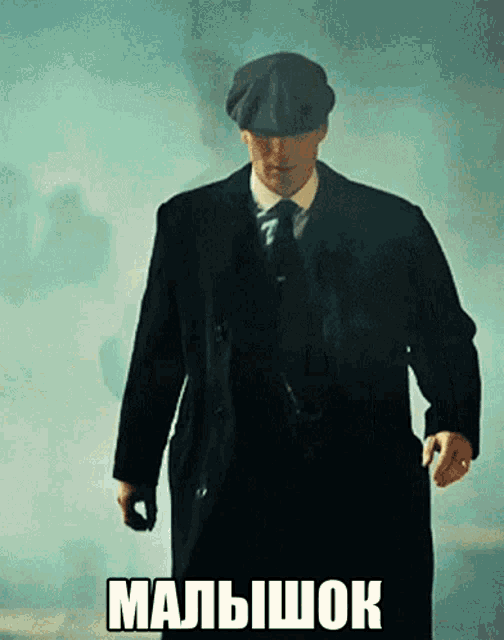 a man in a suit and hat is walking with the word malishok written on the bottom