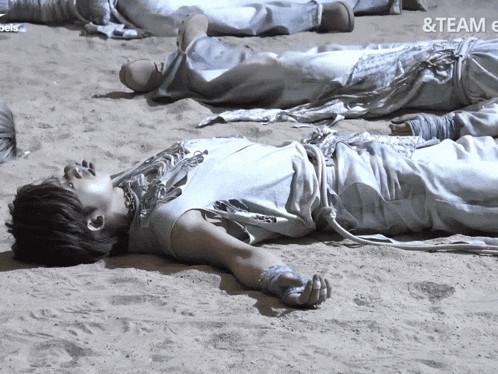 a group of people laying in the sand with the word team on the bottom left