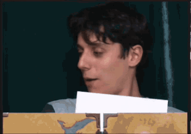 a man is holding a piece of paper in front of him .
