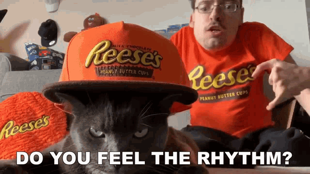 a man wearing a reese 's hat and a cat wearing a reese 's t-shirt