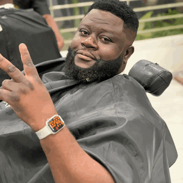 a man wearing an apple watch is giving a thumbs up