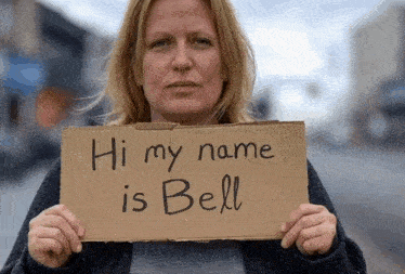 a woman holds up a cardboard sign that says hi my name is bell