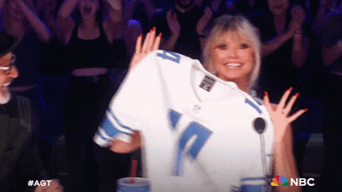 a woman is holding up a football jersey with the number 10 on it