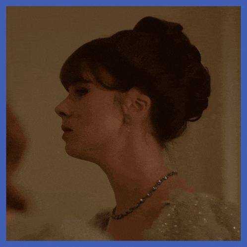 a woman wearing a pearl necklace and earrings looks to the side