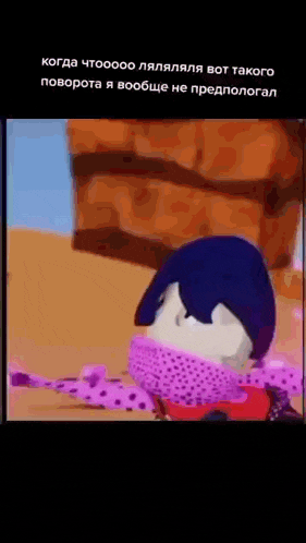 a cartoon character with a pink scarf around his neck is laying on the ground .