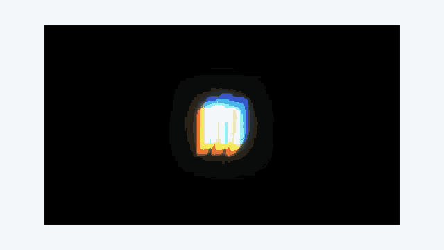 a blurry picture of a rainbow colored light on a black background .