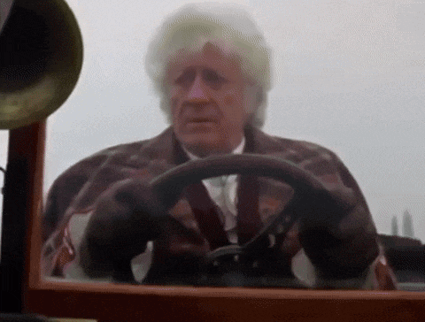 a man is driving a car with a steering wheel in front of a phonograph .