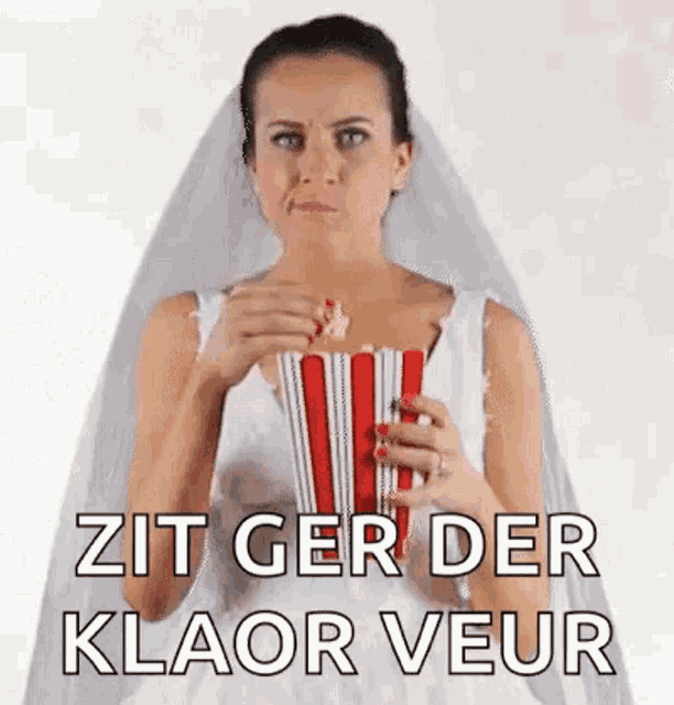 a woman in a bride 's dress is eating popcorn .